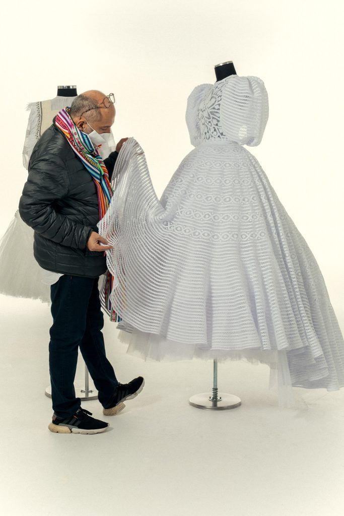 Diego Guarnizo ajustando un vestido de novia sobre un maniquí en su taller de Bogotá