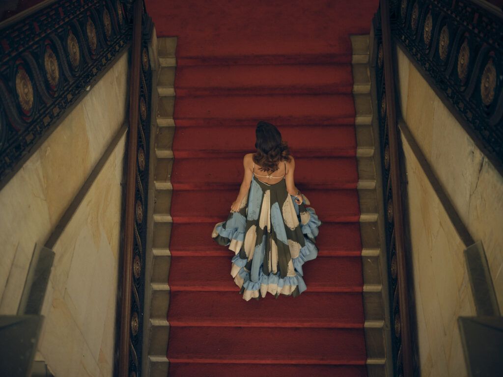 Vestido bordado subiendo una escalera de alfombra roja